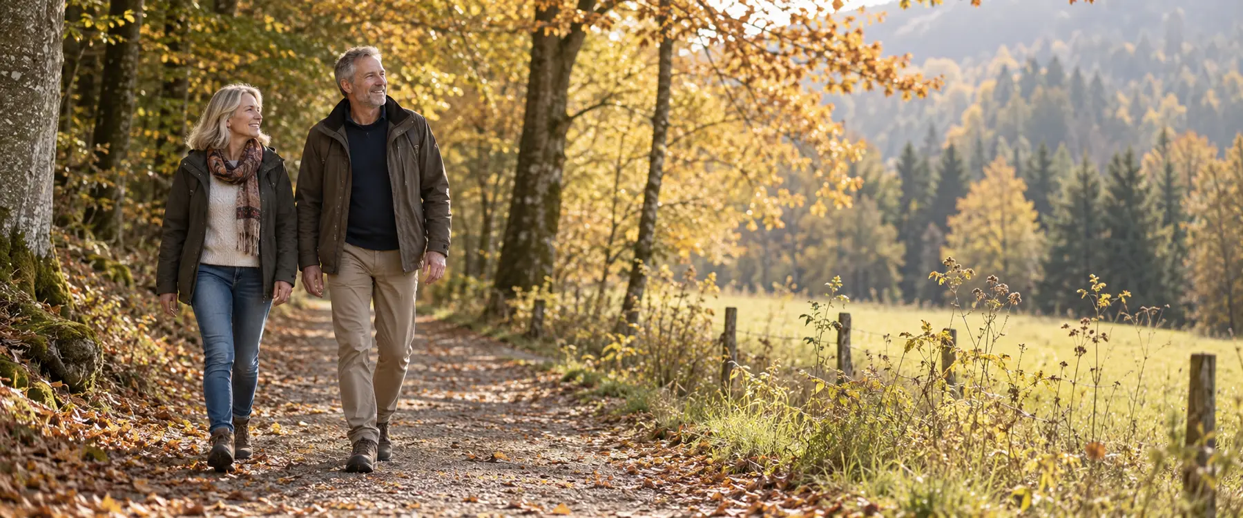 Zwei Erwachsene gehen entspannt auf einem Waldweg